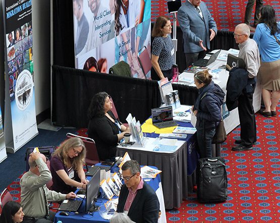 people attending booths at conference
