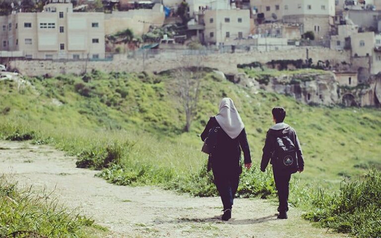 An immigrant woman and her son walk along a trail looking for a doctor