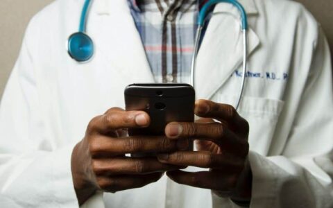 A doctor uses his cell phone